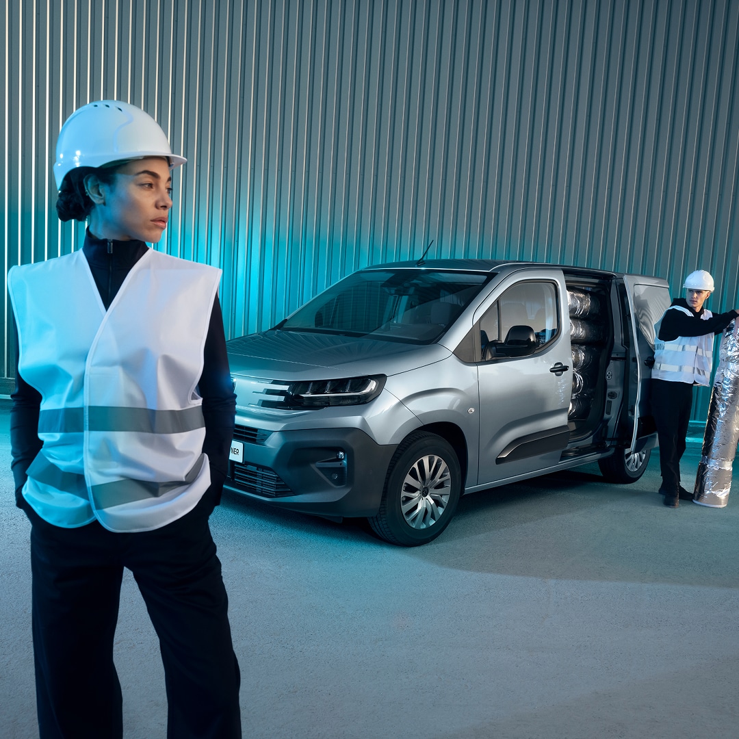 Woman standing in front of a PEUGEOT E-Partner